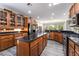 Bright kitchen with gray wood flooring, stainless steel appliances, dark countertops, and wooden cabinets at 10331 Rio De Thule Ln, Las Vegas, NV 89135