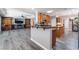 Open concept kitchen with gray wood flooring, dark countertops, wooden cabinets, and an island at 10331 Rio De Thule Ln, Las Vegas, NV 89135