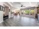 Open-concept living room with hardwood floors, tray ceiling, and large windows overlooking the backyard at 10331 Rio De Thule Ln, Las Vegas, NV 89135