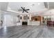 Spacious living room with gray wood floors, a double-door entryway, and an open view to the kitchen at 10331 Rio De Thule Ln, Las Vegas, NV 89135