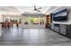 Open-concept living room with gray wood flooring, coffered ceiling, and backyard view from the large windows at 10331 Rio De Thule Ln, Las Vegas, NV 89135