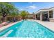 Relaxing backyard pool with a baja shelf, desert landscaping, a covered patio, and a well manicured yard at 10331 Rio De Thule Ln, Las Vegas, NV 89135