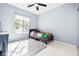 Bright bedroom showcasing a large window, light blue walls, and tile flooring with a gray area rug at 109 Breezy Tree Ct # 202, Las Vegas, NV 89145