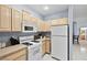 Well-lit kitchen boasts white appliances, wooden cabinetry, and light-colored countertops with tile flooring at 109 Breezy Tree Ct # 202, Las Vegas, NV 89145