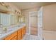 Bathroom with double sinks, wooden cabinets, tiled floors, and access to the bedroom at 1201 Bourbon St, Pahrump, NV 89048
