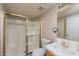 Compact bathroom featuring a walk-in shower with glass doors, toilet, vanity and a large mirror at 1201 Bourbon St, Pahrump, NV 89048