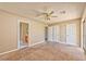 Spacious bedroom featuring neutral paint, carpet, multiple doors, and sliding glass door at 1201 Bourbon St, Pahrump, NV 89048