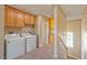 Laundry room with appliances, wooden cabinets and stairs to the second floor at 1201 Bourbon St, Pahrump, NV 89048
