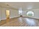 Open-concept living room showcasing wood-style floors, arched window, and staircase at 1201 Bourbon St, Pahrump, NV 89048