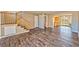 Spacious living room featuring wood-look floors, staircase, and views into the kitchen and backyard at 1201 Bourbon St, Pahrump, NV 89048