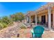 Landscaped backyard featuring covered patio, stone water feature, and mature trees at 1641 Rockcrest Hills Ave, Henderson, NV 89052
