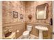 Charming powder room with pedestal sink, decorative mirror, and tiled walls at 1641 Rockcrest Hills Ave, Henderson, NV 89052
