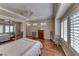 Bright and airy bedroom featuring hardwood floors, shuttered windows, and classic furnishings at 1641 Rockcrest Hills Ave, Henderson, NV 89052