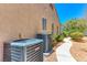 Exterior shot showcasing home's AC units, neutral paint, and well-maintained landscaping at 1641 Rockcrest Hills Ave, Henderson, NV 89052