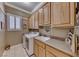Well-lit laundry room features wood cabinets, spacious countertops, washer, and dryer at 1641 Rockcrest Hills Ave, Henderson, NV 89052