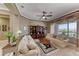 Bright living room featuring comfortable seating, a ceiling fan, and a built-in bookcase at 1641 Rockcrest Hills Ave, Henderson, NV 89052
