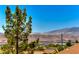 Scenic mountain views visible from this home with lush landscaping, and a red tile roof at 1641 Rockcrest Hills Ave, Henderson, NV 89052