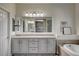 Bathroom featuring double sinks, a soaking tub, and decorative mirrors at 1717 Jake Andrew Ave, North Las Vegas, NV 89086