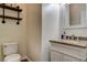 Well-lit half bathroom featuring a granite countertop, traditional fixtures, and a decorative shelf at 1717 Jake Andrew Ave, North Las Vegas, NV 89086