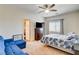 Bright bedroom features a ceiling fan, comfy bed, and blue couch, offering a relaxing retreat at 1717 Jake Andrew Ave, North Las Vegas, NV 89086