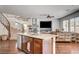 Open kitchen with stainless appliances, center island with seating, and view of living space and stairwell at 1717 Jake Andrew Ave, North Las Vegas, NV 89086
