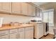 Well-equipped laundry room features cabinetry, countertop space, sink, and modern appliances for efficient chores at 1717 Jake Andrew Ave, North Las Vegas, NV 89086