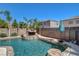 Inviting pool with rock waterfall feature surrounded by lush landscaping and block wall fencing for privacy at 1717 Jake Andrew Ave, North Las Vegas, NV 89086