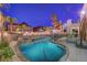 Backyard pool featuring rock waterfall, decorative lighting, and mature landscaping at 1717 Jake Andrew Ave, North Las Vegas, NV 89086