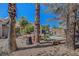 Landscaped backyard featuring palm trees, covered patio, built-in grill, and desert landscaping at 2059 Joy View Ln, Henderson, NV 89012