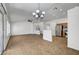 Open-concept living room with tile flooring and modern chandelier, seamlessly flowing into the kitchen area at 2059 Joy View Ln, Henderson, NV 89012