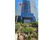 Low-angle exterior of Platinum Hotel & Spa building with blue facade, green foliage, and the US flag at 211 E Flamingo Rd # 405, Las Vegas, NV 89169