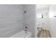 Updated bathroom featuring sleek, gray tiling, a shower-tub combo and updated flooring at 2112 Los Altos St, Las Vegas, NV 89102