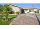 Charming single-story home with manicured lawn, brick-paved driveway and charming curb appeal on a sunny day at 2112 Los Altos St, Las Vegas, NV 89102