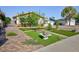 Landscaped front yard with artificial grass, mature trees, desert plants, and brick-paved walkway at 2112 Los Altos St, Las Vegas, NV 89102