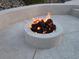 Close-up of a stone fire pit, perfect for cozy evenings spent outdoors in the backyard at 2197 Big Bar Dr, Henderson, NV 89052