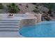 Backyard pool featuring a rock waterfall, fire pit, and elegant steps, perfect for outdoor enjoyment at 2197 Big Bar Dr, Henderson, NV 89052