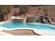 Inviting pool with rock waterfall feature and adjacent patio area at 2197 Big Bar Dr, Henderson, NV 89052