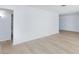 Bright living room with light wood floors, neutral walls, and an open doorway to the bathroom at 2313 Van Patten Pl, Las Vegas, NV 89104