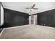 Expansive bedroom featuring plush carpet, ceiling fan, and doors leading to a walk-in closet at 2385 Via Firenze, Henderson, NV 89044