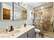Bathroom with dual sinks, updated shower, and modern fixtures with tile throughout at 2426 La Pluma St, Henderson, NV 89014