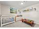 Bright Bedroom with white crib and dresser, and playful decor, creating a warm atmosphere at 2426 La Pluma St, Henderson, NV 89014
