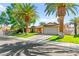 Charming single-story home with a well-manicured lawn, palm trees, and a two-car garage at 2426 La Pluma St, Henderson, NV 89014