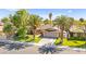 Well-maintained single-story home with lush lawn, mature trees, and a convenient two-car garage offering curb appeal at 2426 La Pluma St, Henderson, NV 89014