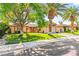 Inviting single-story home featuring mature trees, a well-maintained lawn, and a cozy front porch at 2426 La Pluma St, Henderson, NV 89014