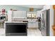 Well-lit kitchen with stainless steel appliances, a white farmhouse sink, and a functional island at 2426 La Pluma St, Henderson, NV 89014