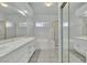 Bright bathroom features dual sinks, tile floors, a bathtub, and a glass shower at 2537 Seascape Dr, Las Vegas, NV 89128