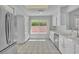The bright kitchen offers white cabinets, stainless steel appliances, and a window overlooking the yard at 2537 Seascape Dr, Las Vegas, NV 89128