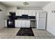 Functional kitchen with white cabinets, black appliances, and dark tile flooring at 256 Winona Ter, Henderson, NV 89015