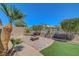 Landscaped backyard featuring a fire pit, artificial grass, mature landscaping, and privacy wall at 2779 Kindeace Ave, Henderson, NV 89044