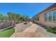 Paver backyard featuring lush landscaping, fire pit, artificial turf, and mature trees at 2779 Kindeace Ave, Henderson, NV 89044